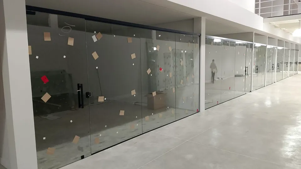Corredor comercial com divisórias e portas de vidro temperado executadas pela CCS Vidros.