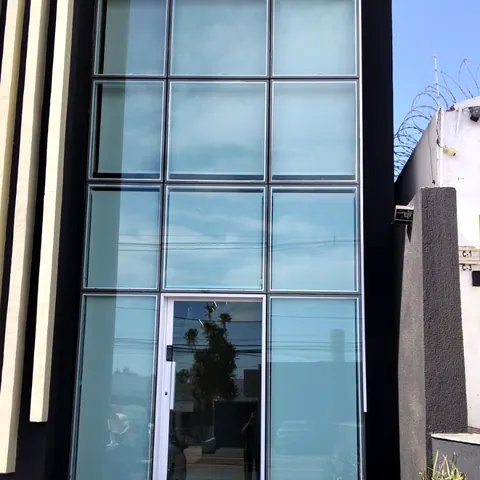 Fachada comercial em pele de vidro com estrutura de alumínio.