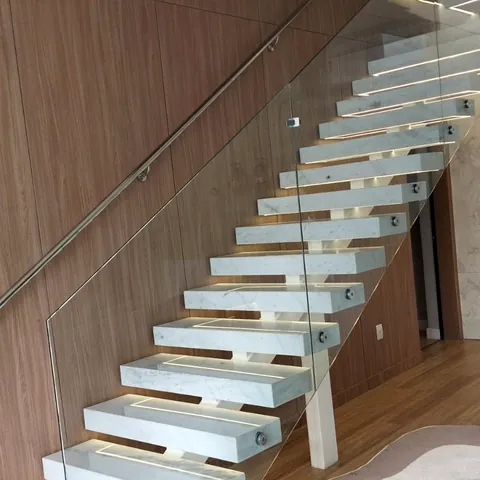 Guarda-corpo de vidro com fixação metálica em escada.