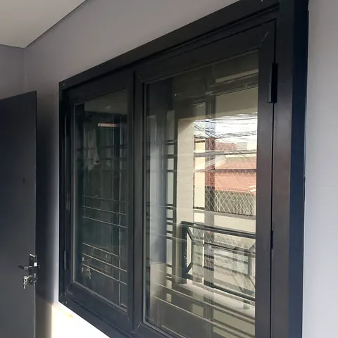 Janela de alumínio preto com folhas de abrir, instalada pela CCS Vidros.
