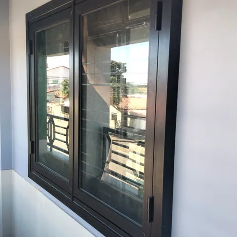 Janela de alumínio preto em varanda, vista de dentro do imóvel.