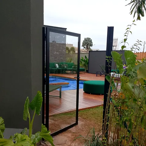 Porta de vidro para área externa com estrutura de alumínio preto.